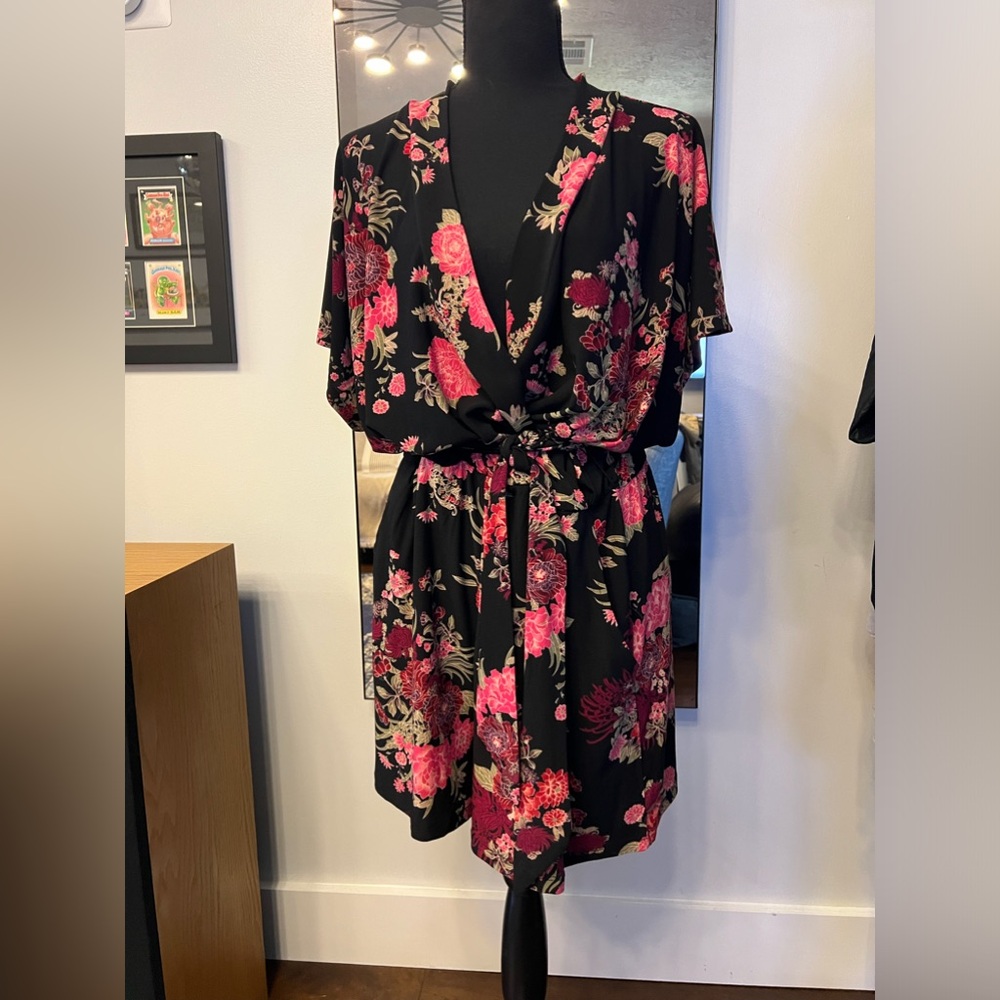 Adorable romper. Black with floral print. Wrap style with belt.